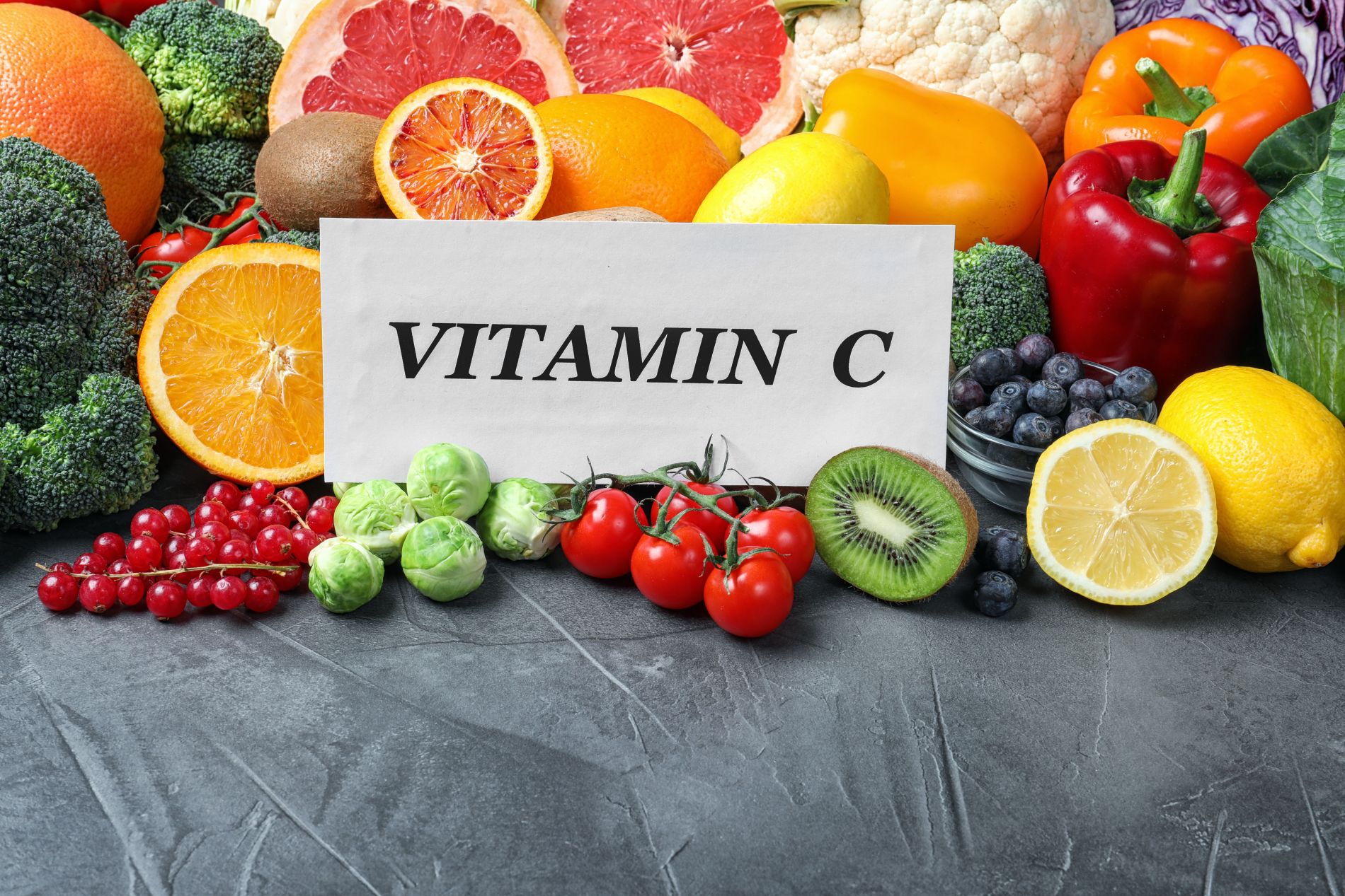 Owoce i warzywa z tabliczką z napisem vitamin c